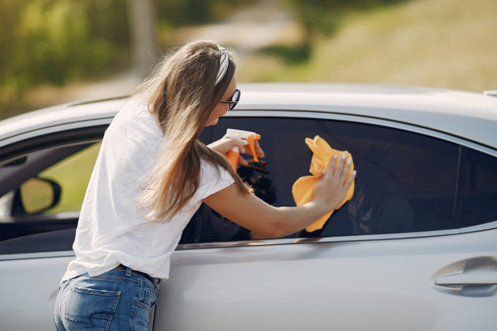 woman cleaning car window